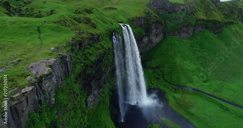 Aerial view of dramatic giant waterfall Seljalandsfoss flowing in Iceland in slow motion 
