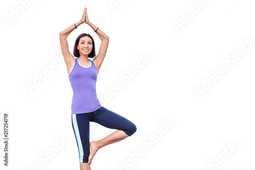 Woman doing yoga standing asana isolated on white © EdNurg