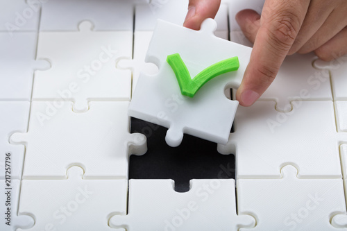 Human hand solving jigsaw puzzle