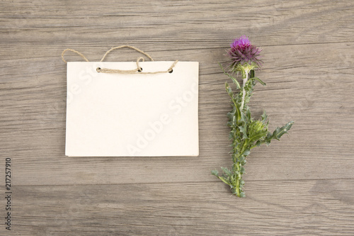 Purple wildflowers with handmade craft notebook on old grunge wooden background. Top view. Minimalistic mockup photo