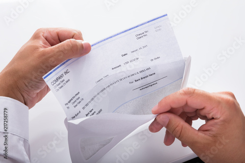 Businessman opening envelope with paycheck