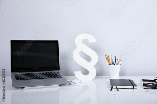 Laptop And Paragraph Symbol On Reflective Desk