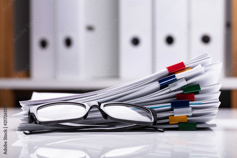 Stacked Documents And Eyeglasses Stacked Documents And Eyeglasses