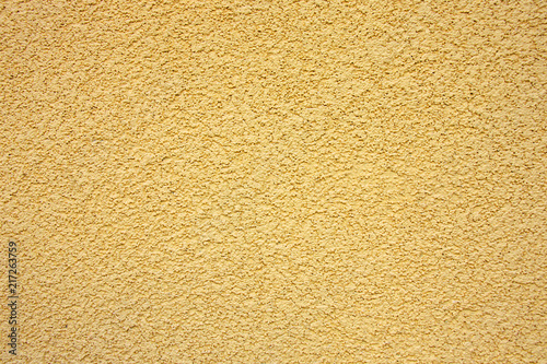 Bright stucco yellow wall background or texture
