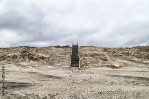 Wooden staircase among the sand on a cloudy day