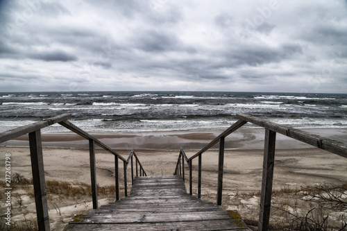 Wooden staircase among the sand on a cloudy day