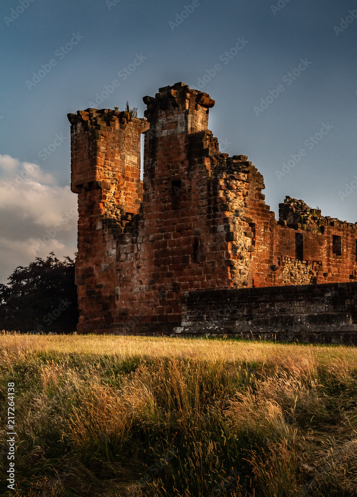 Gorgeous moody shot of the corner portion and surrounding wall of Penrith Castle at sunset in Cumbria, England UK.