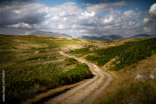 Beautiful moody and cloudy view of the road leading to Devoke Water in the Lake District in Cumbria, England UK.