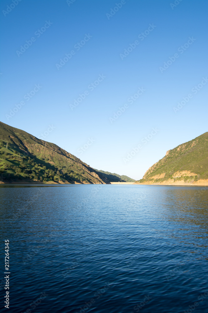 Calm blue water of reservoir in sunlight