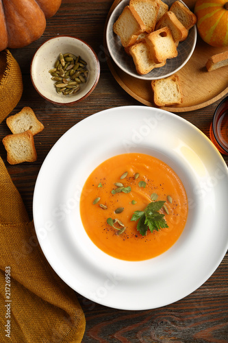 pumpkin soup in plate on boards, food flat lay