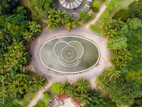 aerial view of man made pond with fountain in park in Barra da tijuca, Rio de janeiro. Drone pov shows geometric shapes and patterns, including circles and elipses