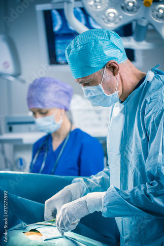 Vertical Shot of a Professional Surgeon Performing Invasive Surgery on a Patient in the Hospital Operating Room. Surgeon Use Instruments. Real Modern Hospital with Authentic Equipment.