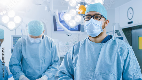 In the Operating Room Surgeon Gestures Using Augmented Reality Technology During Operation. In the Background Assistants and Nurses Working with Real Equipment.