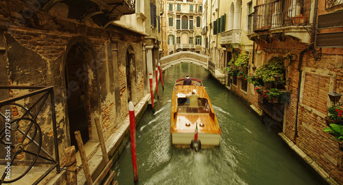 dark scene of narrow canal in Venice. boat in motion
