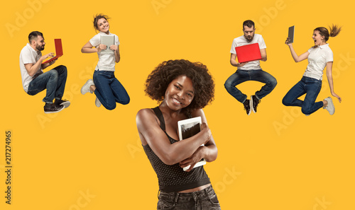 Businesswoman with laptop and jumping man and woman. Love to computer concept. Attractive female half-length front portrait, trendy studio backgroud. Young afro emotional woman. Human emotions