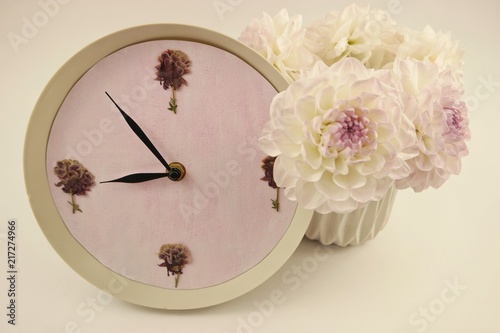 Fototapeta Naklejka Na Ścianę i Meble -  The decorative clock and vase with white dahlias on the white background