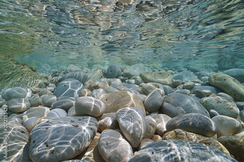 Pebbles and rocks below water surface in shallow water in the Mediterranean sea, underwater scene, Javea , Alicante, Valencia, Spain
