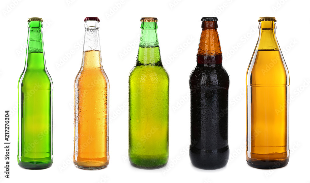 Different bottles with fresh beer on white background
