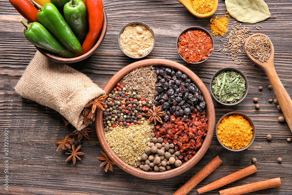 Composition with different dry spices on wooden background