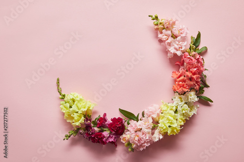 top view of beautiful tender pink, white, yellow and red flowers on pink background