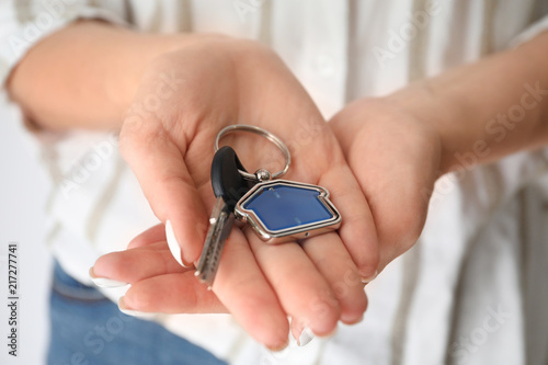 Woman holding key with trinket in shape of house, closeup