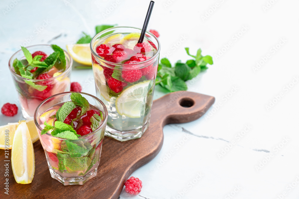 Glasses of fresh raspberry mojito on light table Glasses of fresh raspberry mojito on light table