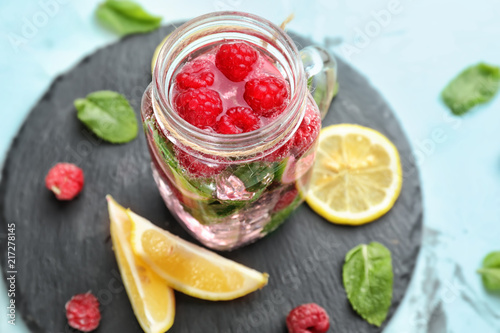 Mason jar of fresh raspberry mojito on table