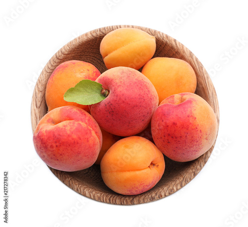 Bowl with ripe sweet apricots on white background