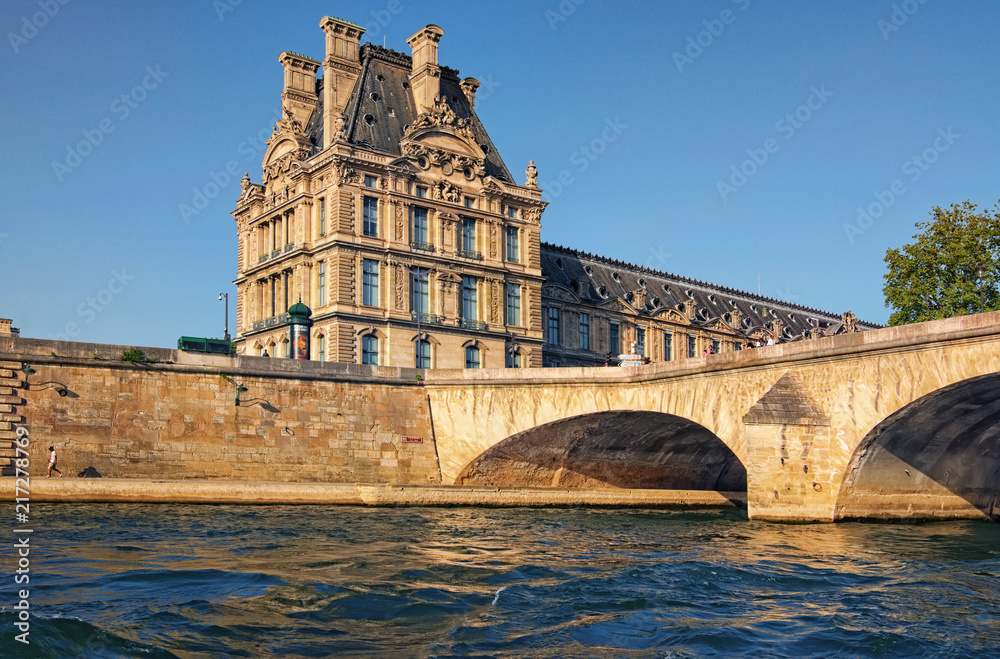 Paris, France-MAY 06, 2018: The picturesque embankment of the Seine River, ancient building and the bridge during sunset. Paris, France