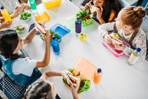 high angle view of group of schoolgirls taking lunch at school cafeteria
