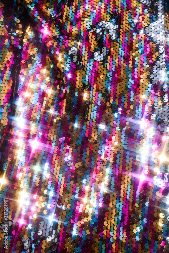 Sequins close-up macro. Abstract background with sequins colorful on the fabric. Texture scales of round sequins 