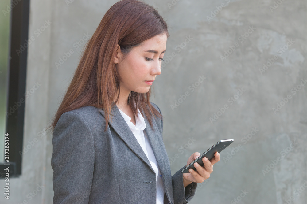 Portrait of an professional investment advisor businesswoman looking at her smartphone and smiling. Portrait of an professional investment advisor businesswoman looking at her smartphone and smiling.