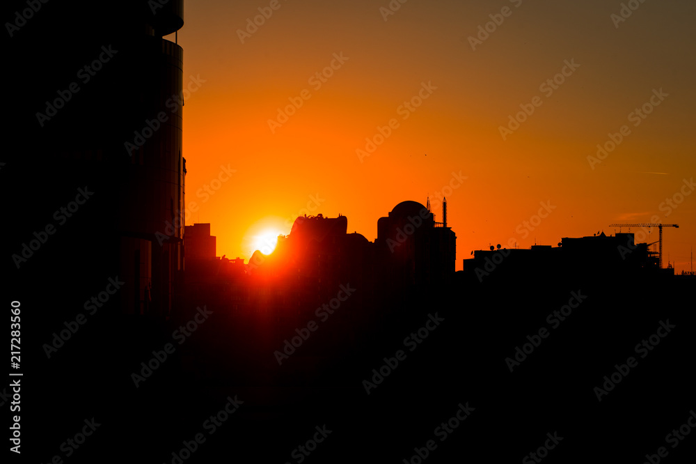 Silhouettes of high-rise buildings at sunset. Sunset over the city. Cityscape at sunset.