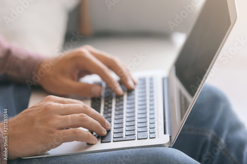 Freelancer working on laptop at home, closeup