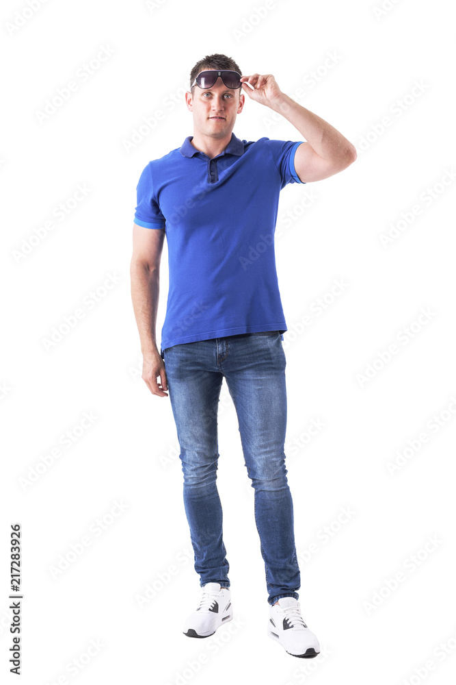 Front view of young adult casual man remove sunglasses and looking at distance. Full body isolated on white background. Front view of young adult casual man remove sunglasses and looking at distance. Full body isolated on white background.