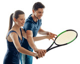 Man training woman to play tennis. Couple of young athletes having fun during a practice, working on hits.