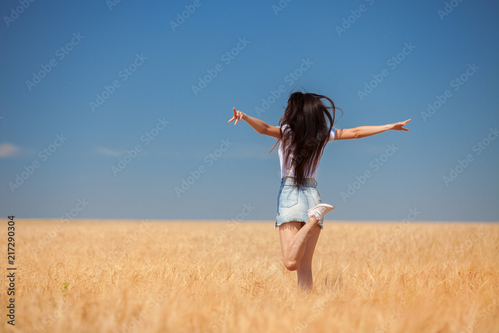 Happy woman enjoying the life in the field Nature beauty, blue cloudy sky and colorful field with golden wheat. Outdoor lifestyle. Freedom concept. Woman jump in summer field Happy woman enjoying the life in the field Nature beauty, blue cloudy sky and colorful field with golden wheat. Outdoor lifestyle. Freedom concept. Woman jump in summer field