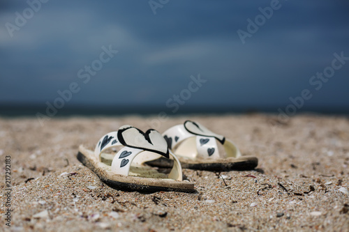 white slippers on the beach against the background of the sea