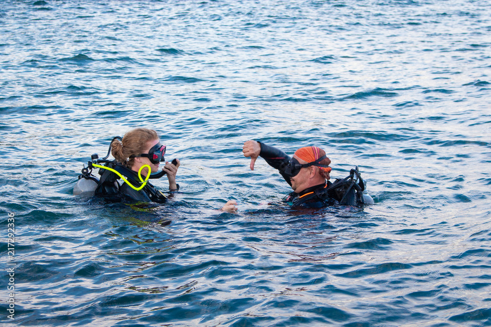 divers dive into the water