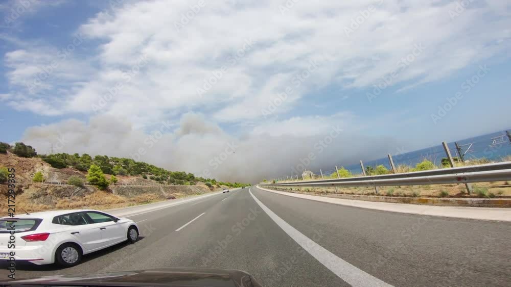 View from a car driving on the highway approaching Kineta and entering into a smoke cloud from the wildfire. One of the largests wildfires of Attica during that summer in Greece.