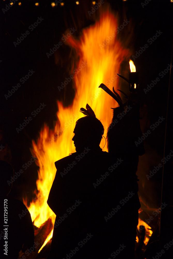 Silhouette of an Indian at a campfire
