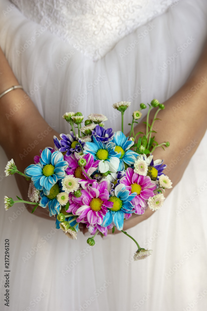 Bride holding colored flowers bouquet