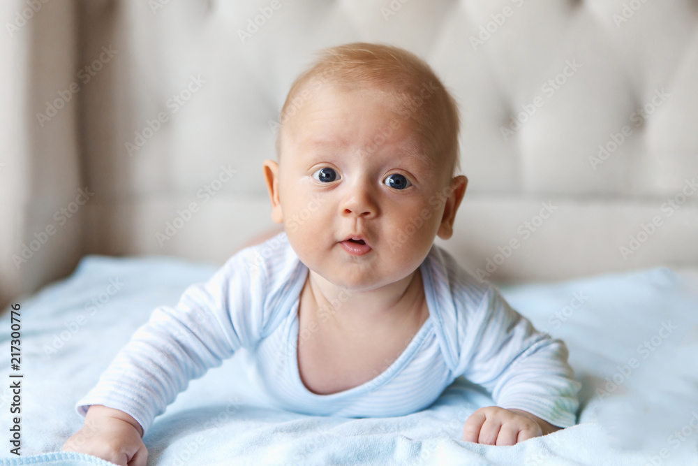 Charming baby in blue body, lying on tummy Charming baby in blue body, lying on tummy