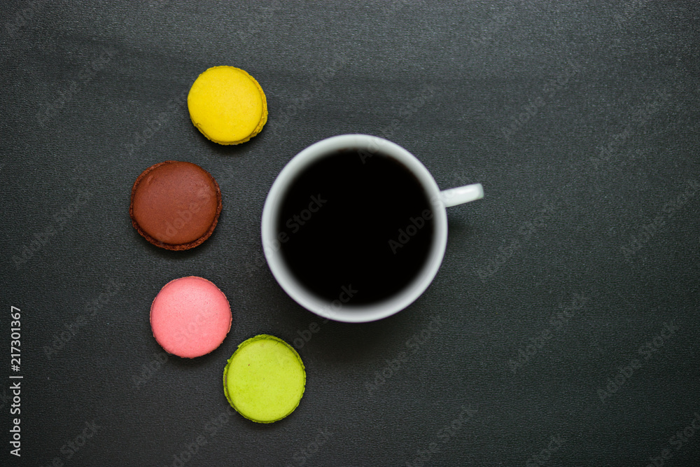 Top view cup of coffee and french macaron on black background, good morning Top view cup of coffee and french macaron on black background, good morning