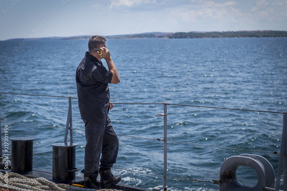 marine black camouflage officer and boots hold a radio station on the deck of a warship in the Black Sea/Bulgaria/07.19.2018/ service and work on a warship. working on water