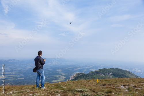 Young man flying drone over mountain