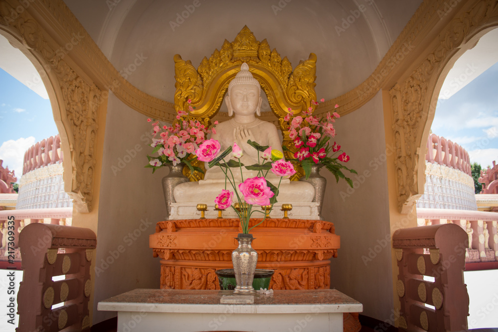 white buddha statue with gold decoration at the back