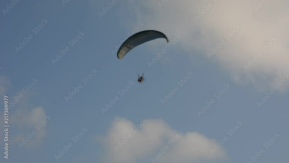 Silhouette of a male paraglider on a paraplan against a background of a sunset in the sky and clouds hovering over the sea. Concept: freedom, loneliness, hobby, sport. Silhouette of a male paraglider on a paraplan against a background of a sunset in the sky and clouds hovering over the sea. Concept: freedom, loneliness, hobby, sport.