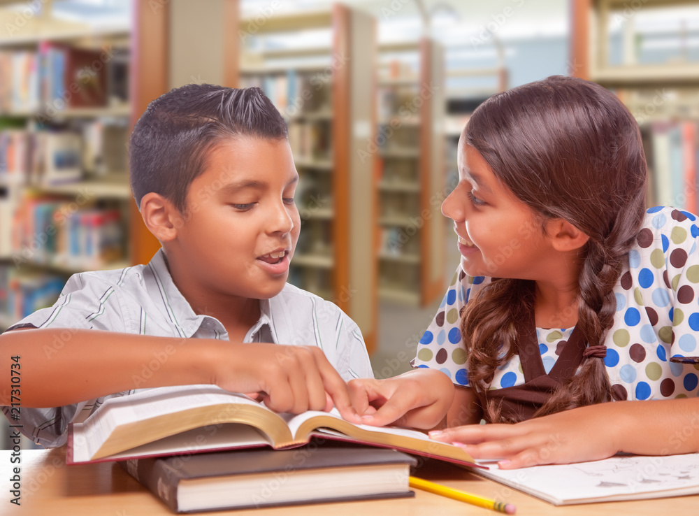 Hispanic Boy and Girl Having Fun Studying Together In The Library Hispanic Boy and Girl Having Fun Studying Together In The Library