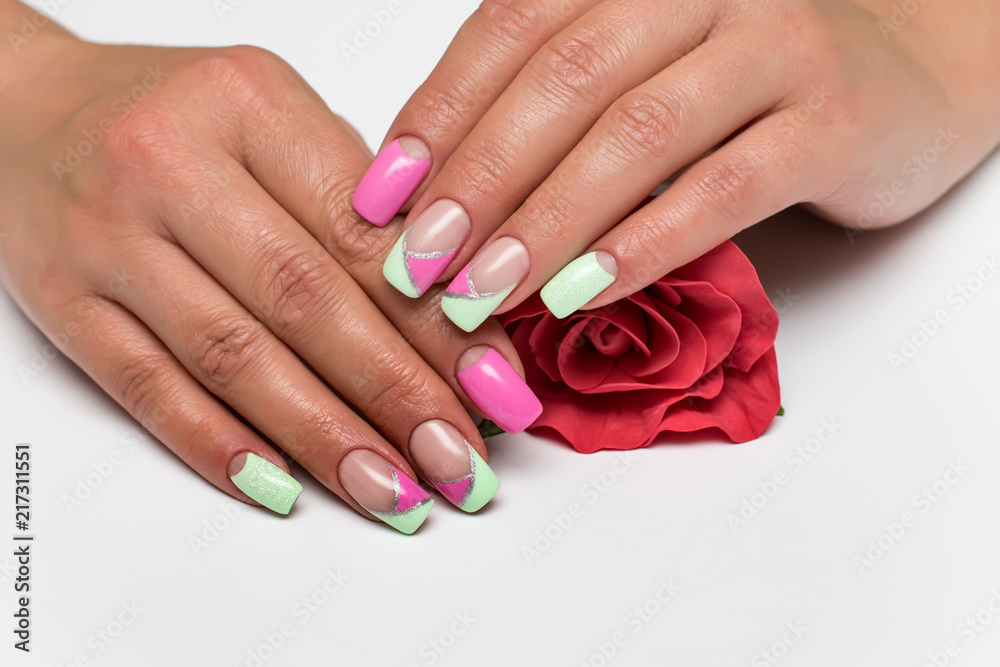 summer mint pink manicure with silver stripes on long square tanned hands with a red rose in hands 